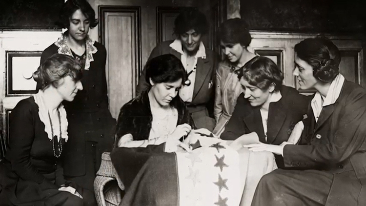 caption: Alice Paul sewing the last star on the ratification flag.