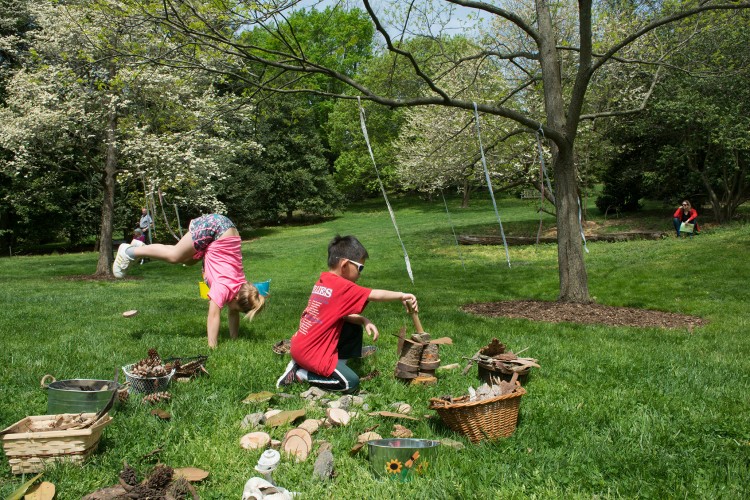 caption: At left, During May’s event Raya, age 11, practiced her handstands and Alex, age 7, built a tower with tree slices and bark. Photograph by Julia Lehman.