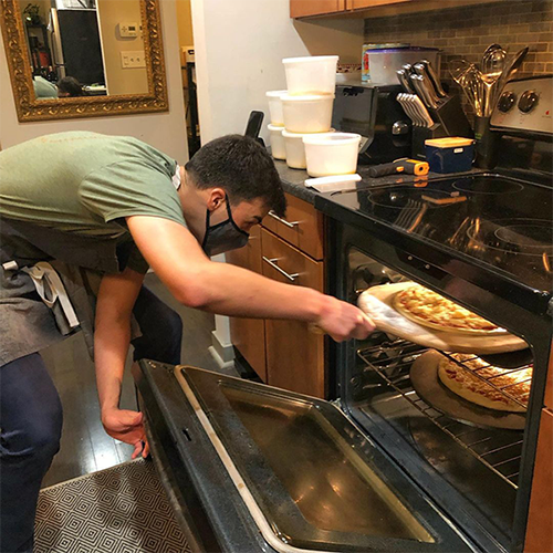 caption: Ben Berman pulls another Good Pizza out of the oven. 