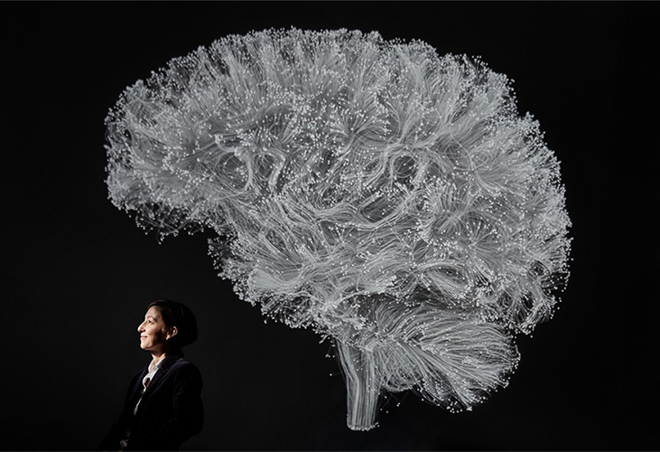 caption: Danielle Bassett with visualization of the brain's structural connections.