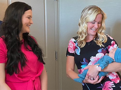 caption: Womb donor Chelsea Jovanovich (left) smiles on as Cheryl Urban (right) meets her son Telden for the first time.