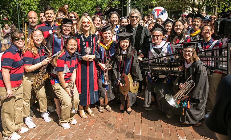 caption: President Amy Gutmann and Jon Bon Jovi paused with the Penn Band.