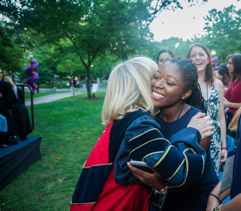 caption: President Amy Gutmann hugs a student.