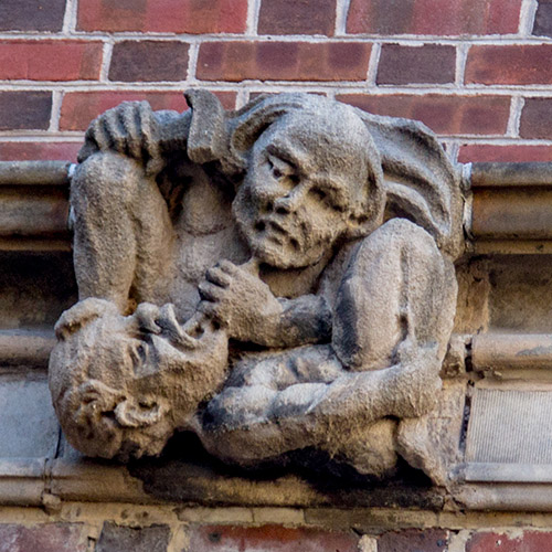 caption: The grotesques on Penn Dental’s Evans building exhibit a sense of humor. In this scene, one creature extracts the tooth of another!