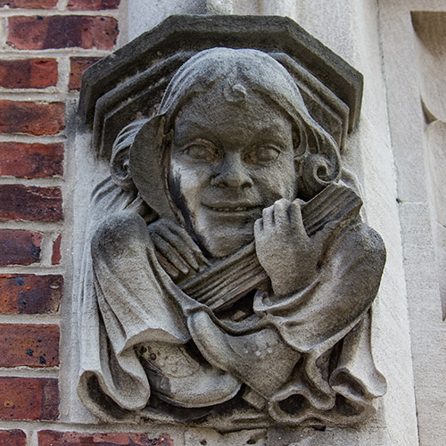 caption: This figure, which adorns the front entrance of Fisher-Bennett Hall, seems to depict a woman, which is apropos of the building’s original role as Penn’s College for Women. 