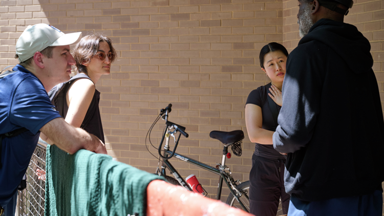 caption: Connie Yu, Setareh Gooshvar, and Zachary Kosek, a family medicine physician, visit with Victor during one of the group’s outreach walks.