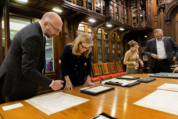 caption:  Sean Quimby, associate university librarian & director, Jay I. Kislak Center for Special Collections, Rare Books, and Manuscripts and director of the Schoenberg Institute for Manuscript Studies, shows Penn President Liz Magill items from the collection displayed in the Lea Library on the sixth floor of Penn's Van Pelt Library. Photos courtesy Eric Sucar. 