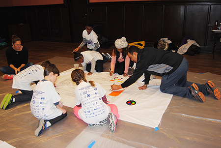 caption: Students taking part in the Children’s Banner Painting activity last year.