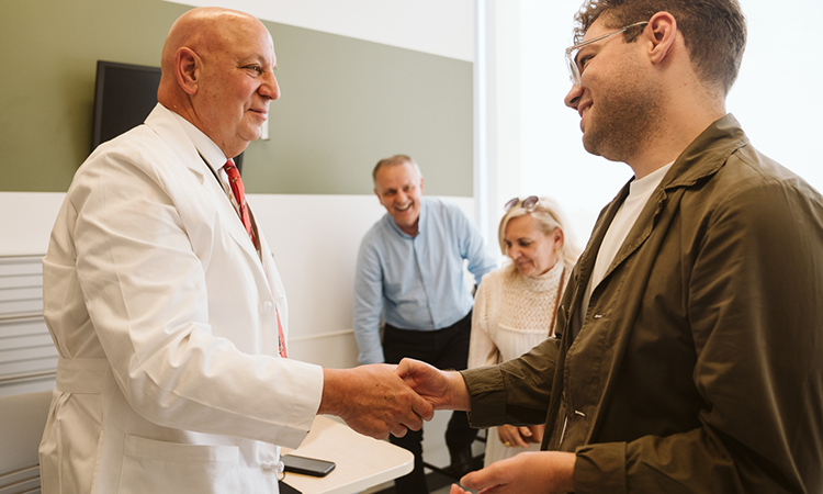 caption: Penn hand transplant program director and orthopaedic and plastic surgeon L. Scott Levin with Luka Krizanac.