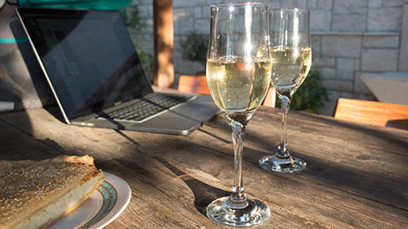 Two glasses of champagne near a laptop
