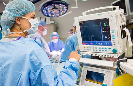 Woman looking at heart monitor in operating room