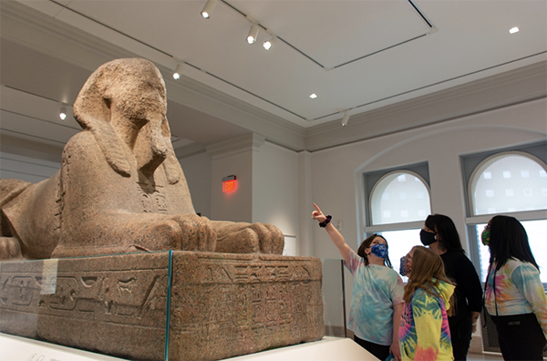 caption: Visitors to the Penn Museum viewing the Sphinx.