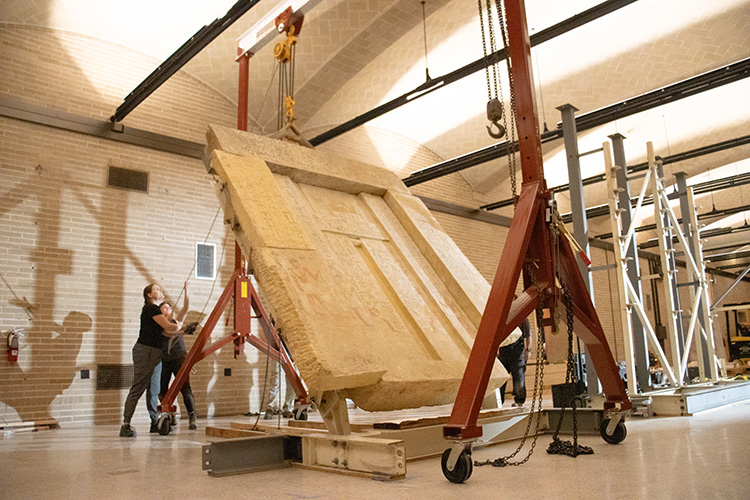 Conservators hoist a 5-ton “false door” as part of  the installation of the Tomb Chapel of Kaipure in the Penn Museum’s Ancient Egypt and Nubia Galleries.