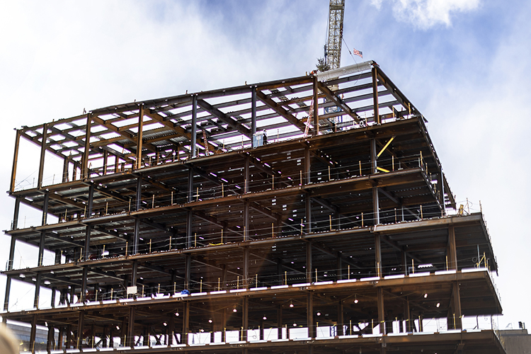 caption: The final steel beam was hoisted atop the Vagelos Laboratory for Energy Science and Technology. The moment was one that signals “Penn’s rise as a global leader in energy science,” said President Liz Magill, who was joined for the celebration by donor P. Roy Vagelos and deans Steven Fluharty and Vijay Kumar, as well as students, faculty, and staff from across the University. Photo by Eric Sucar.