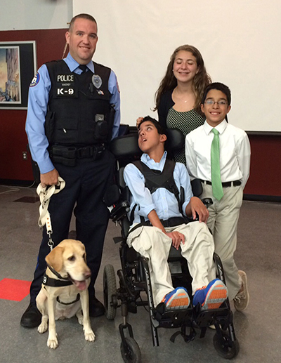caption: Zsiza, also a Working Dog Center graduate, and partner Sean Mackey with visitors.