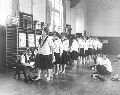 caption: Women students having imprints made of their feet, on February 17, 1927, in Bennett Hall gymnasium as part of physical education, “In order that defects may be detected and corrected.”