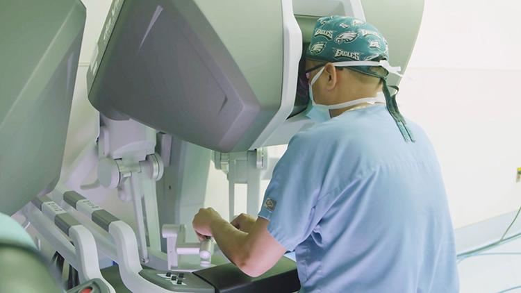 caption: Surgeons at Pennsylvania Hospital use a robot as part of a bilateral breast reconstruction.